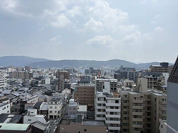 京都五条の街並みと、緑豊かな山々が調和する風景です。四季の移ろいを身近に感じられそうです。【住戸からの眺望写真】