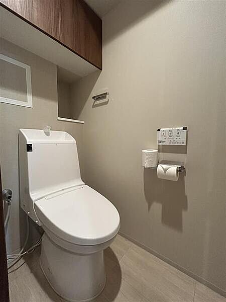 温水洗浄便座付きです。上部に吊戸棚があり、トイレットペーパーなどのストックにご活用いただけます。【トイレ】