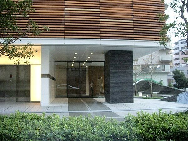 テラコッタルーバーと御影石の壁が重厚な表情をつくり出すエントランス。住まいに上質な趣を添えます。【現地外観写真】