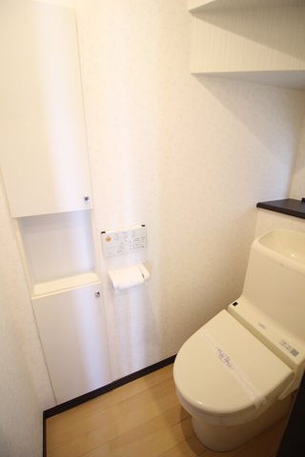 温水洗浄便座付きのトイレ。壁面には小物入れも設置されています