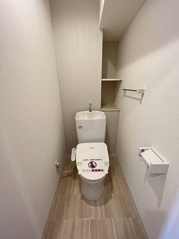 快適な温水洗浄便座付きのトイレ。棚には、トイレットペーパーや掃除用品などが収納できます。