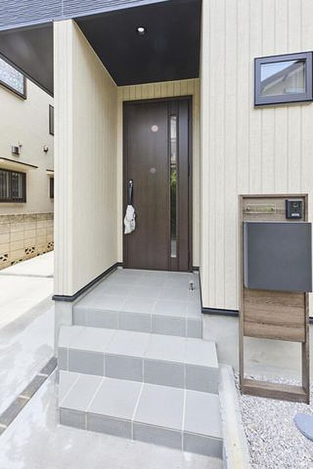 木目調の玄関ドアが迎える落ち着いたアプローチ空間