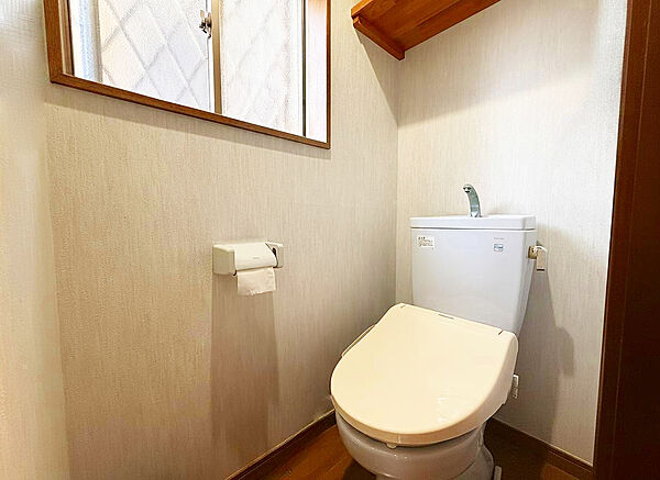 窓からの自然光で明るく清潔感あふれるトイレ空間。便利な上部棚も備えています。※掲載の室内写真は、生成AI（CG）で家具・小物を消したものとなります。実際の室内状況は現地を確認ください。