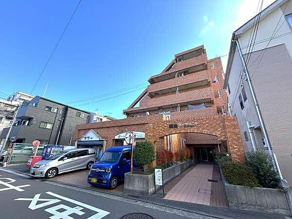 【現地外観写真】マンション入り口には植栽が施されており、四季を感じる暮らしができそうです。/2025年12月撮影