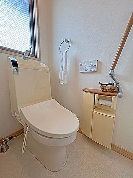 【2階トイレ】手すりや収納が付いており、使い勝手のよいトイレです。温水洗浄便座付きで快適に使用できます。/2026年6月撮影