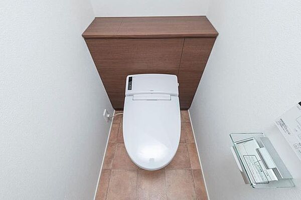 【1階トイレ】独立した手洗い器が設置されています。背面に棚が備わっており、トイレットペーパーなどのストックが可能です。