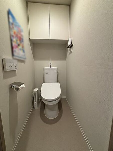 【トイレ】温水洗浄便座＋手洗い器付き。背面上部に吊戸棚があり、トイレットペーパーなどのストックが可能です。