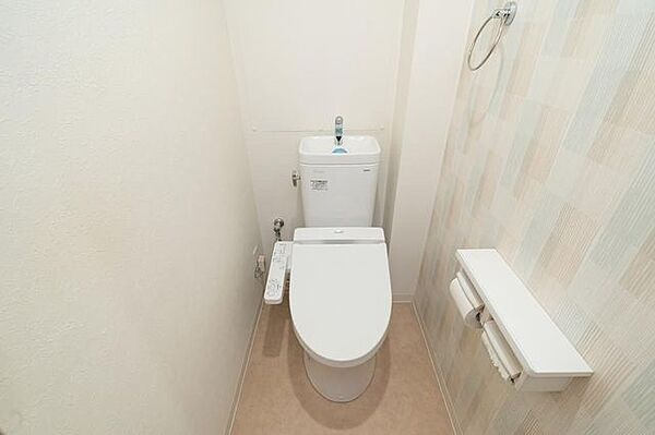 【トイレ】手洗い器＋温水洗浄便座付き。タオルハンガーと、2連式のトイレットペーパーホルダーが備わっています。
