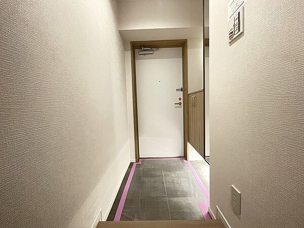 ダークな床色は汚れが目立ちにくく、下駄箱下の隙間や棚部分を設けた、すっきりしていて機能的な玄関です
