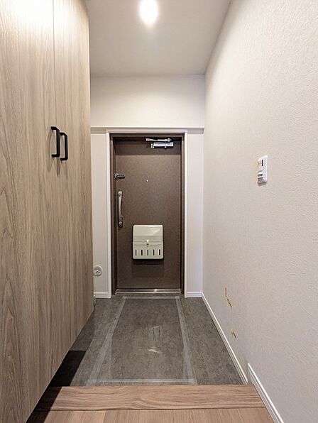 落ち着いた色合いでまとめられた玄関スペース。住まいの第一印象をすっきりと演出します。