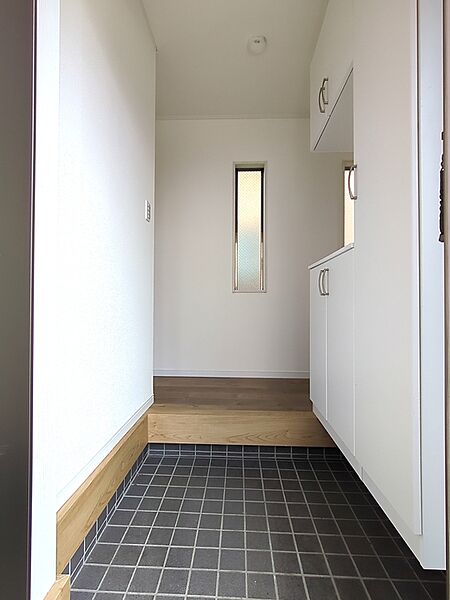白を基調とした明るい空間に、スリット窓からの光が差し込む、清潔感にあふれた爽やかな玄関です。家族みんなの靴をすっきりと収納できる大型シューズボックスを完備！
