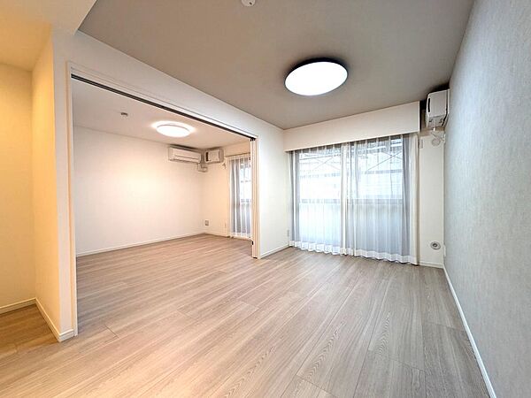 大きな窓から光が入り込む、明るいリビングダイニングです。隣の洋室の引き戸を開放すれば、さらに広々とした大空間に変身。子どもの遊び場や家族の成長に合わせてフレキシブルに使える、便利な間取りです。