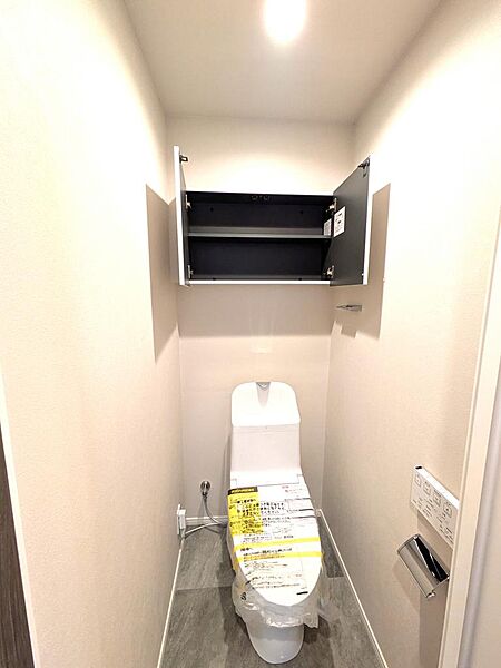 上部吊戸棚付きですっきり片付く、清潔感溢れるトイレ！トイレットペーパーや掃除用品を隠して収納できるため、生活感を抑えて綺麗に保てます。温水洗浄便座や壁掛けリモコン完備で操作しやすく、お手入れも簡単。