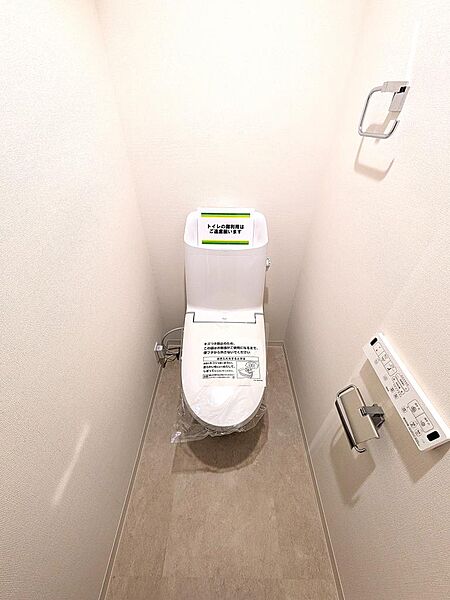 壁掛けリモコン付きで操作がスムーズな温水洗浄便座仕様のトイレです。手すりが設置されており、どんな世代の方でも安全・快適に利用可能。クリーニング済みで、新生活を気持ちよくスタートできます。