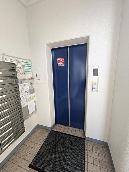 鮮やかなブルーのドアが印象的なエレベーター完備で上階への移動も快適！エントランス内には整然とした集合ポストや掲示板を備え、手入れの行き届いた良好な管理体制がうかがえる快適な共用スペースです。