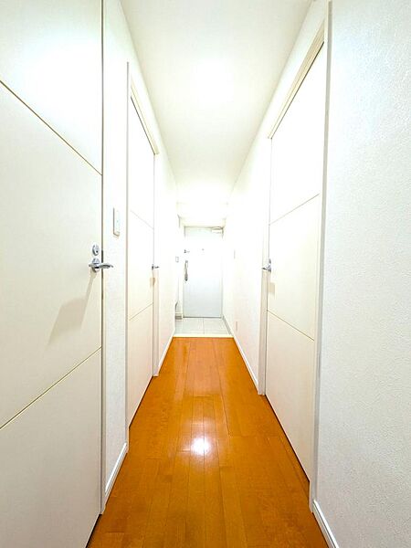 【廊下】LDK側から玄関方向を見通した内観。廊下を中心に各洋室やトイレが独立して配置されており、家族間でもプライバシーをしっかりと確保しやすい、生活動線に優れた間取りです。
