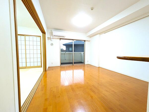 【LDK（約13帖）】家族が集うゆとりあるリビングダイニング。隣接する和室の引き戸を開放すれば、さらに広々とした一体感のある大空間として活用できます。お好みの家具を自由に配置しやすいシンプルな空間です