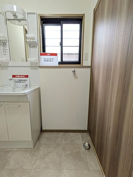 新品に交換された洗面化粧台と、張り替え済みの清潔なクッションフロアが魅力の洗面脱衣室。洗濯機置き場の上部には小窓があり、換気もしやすく快適です。