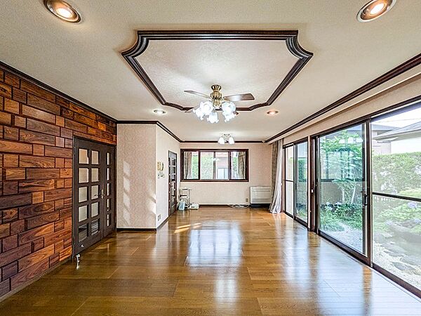 庭に面した大きな窓から光が差し込む約16帖のリビング。折り上げ天井が空間の広がりを演出します。