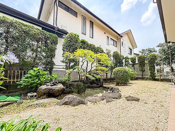 白砂利が敷き詰められ、造園石や池が配された和の情緒あふれる庭。和室から四季の移ろいを楽しめます。