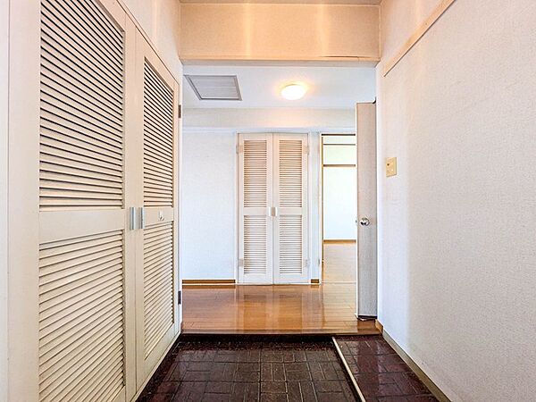 白を基調とした清潔感のある玄関ホール。廊下正面にも収納を備え、住空間の整理整頓に役立ちます。