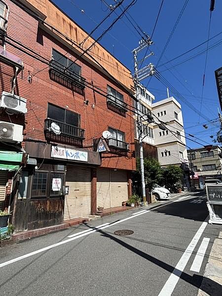 【現地外観】どこか懐かしさを感じる外観の店舗付き中古テラス。道路に面した1階店舗と、上階の住居を備えています。