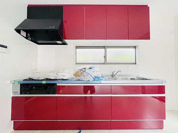 深紅色の素敵なシステムキッチンを導入。収納力も十分にあります！