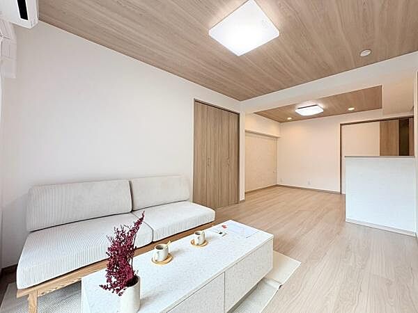 約14.5帖のリビングダイニングキッチンです。やわらかな木目調の天井が印象的な空間です。シンプルなデザインが魅力的です。家具の配置もしやすい間取りです。ソファセット、エアコン1台付き。