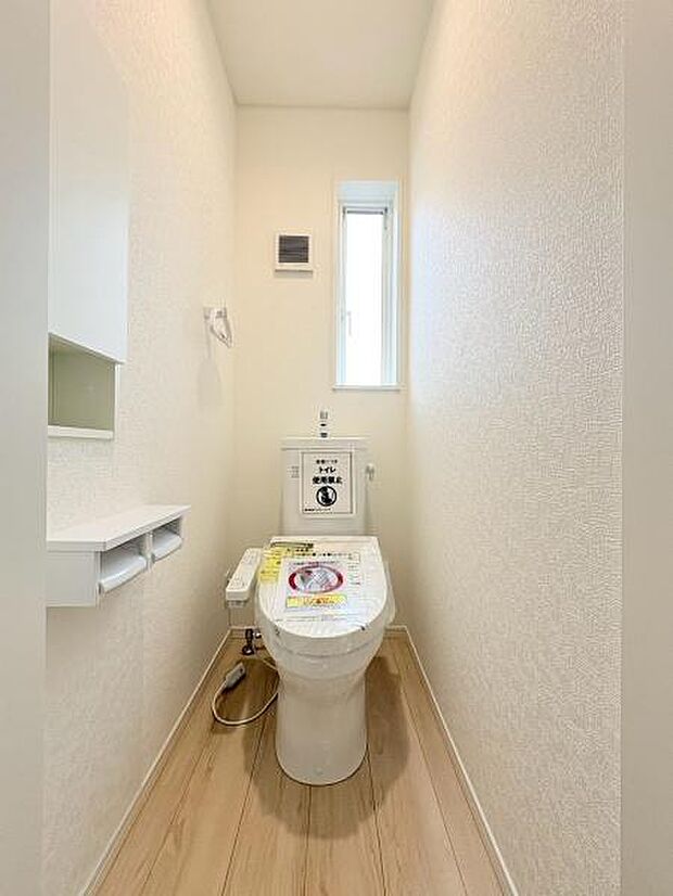 清潔感のある明るいトイレです。コンパクトながら必要な設備がしっかりと揃っています。窓があるため換気もしやすい仕様です。床の木目調がやさしい雰囲気を演出しています。