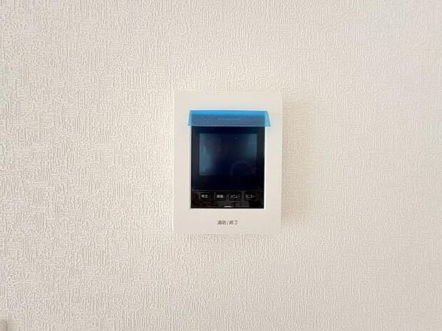 シンプルなデザインのモニター付きインターホンが設置されています。壁面にすっきりと収まる設計です。操作ボタンが分かりやすく配置されています。使いやすさを意識した設置がされています。