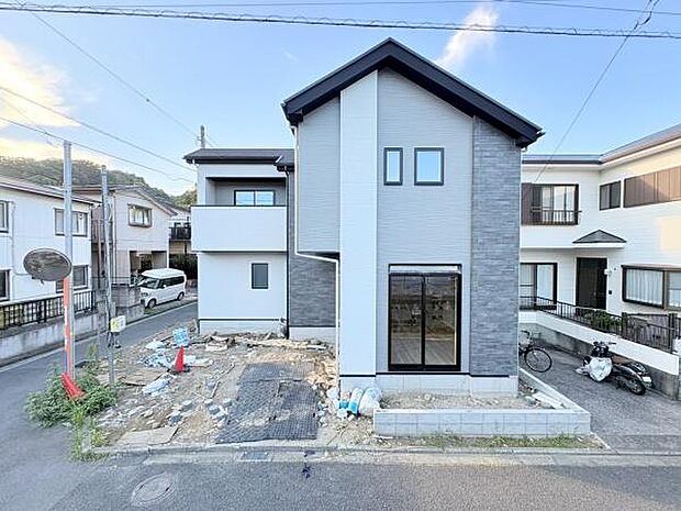 シンプルな外観デザインが際立つ新築物件です。周囲に同系統の住宅が並び落ち着いたエリアに所在しています。前面道路は幅があり出入りがしやすい点も特長です。