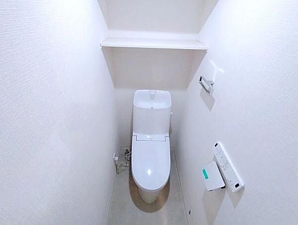 トイレ背面の高い位置に棚が設置されています。トイレットペーパーのストックや掃除用品、あるいはディフューザーなどの小物を置くのに便利です。