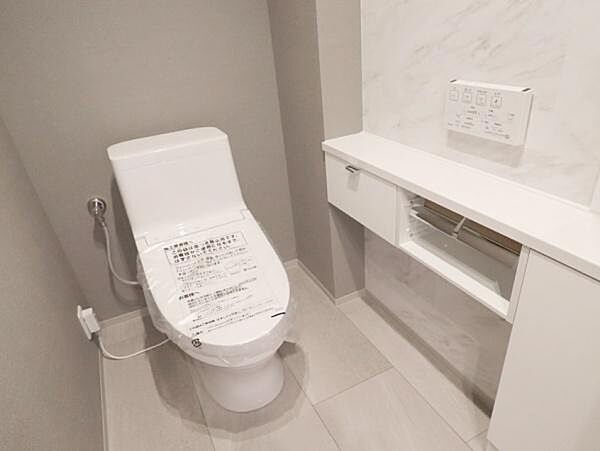 壁面に横幅のあるカウンターが設置されており、その下が収納スペースになっています。トイレットペーパーのストックや掃除用具を隠して収納できるため、スッキリとした状態を保てます。