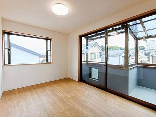 バルコニーに面した明るい自然光がたっぷりと降り注ぐ心地よい洋室です。温かみのある木目調フロアとすっきりとしたホワイト基調のデザインが調和し、穏やかでリラックスできる空間に仕上がっています。