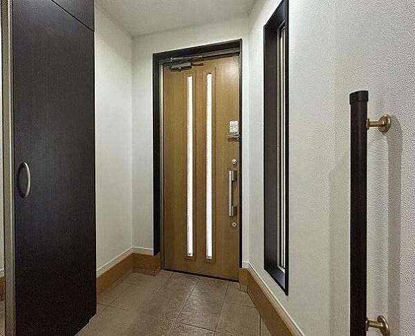 玄関ドアのスリットガラスに加え、サイドに縦長のスリット窓を配置。日中はやわらかな自然光が差し込み、明るい空間で家族やゲストを迎えられます。
