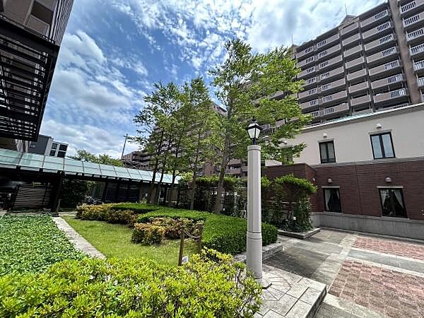 クラシカルでスマートなデザインの街灯、温かみのある幾何学模様のインターロッキング舗装、レンガ調の重厚な低層壁が調和した、まるで海外の広場のような上質な趣があります。