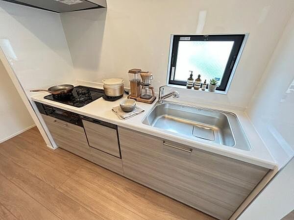 木目調の美しさと調和するモダンなシステムキッチン。美しいデザインを損なわない一体型の食器洗い乾燥機を標準装備しています。（調度品はAI生成となります。）