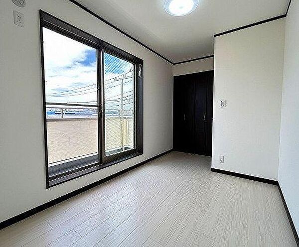 窓からたっぷりと自然光が差し込む、爽やかなお部屋です。バルコニーに直接出ることができ、お洗濯干しもスムーズ。白い床と壁が部屋全体を広く見せ、ダークカラーの建具が空間を引き締めるモダンなデザインです。