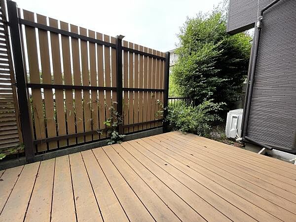 ウッドデッキのナチュラルな木質感と周囲の青々とした植栽の緑が美しく調和し、日々の生活に心地よい癒やしをプラスします。