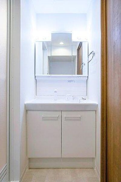洗面化粧台には、身支度に便利な三面鏡を採用。鏡の裏は収納スペースになっており、洗面まわりの小物をすっきりと片付けられます。
