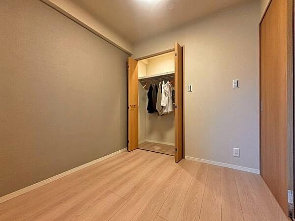 4帖の納戸～落ち着きのあるニュアンスグレーのアクセントクロスが施された納戸。お部屋の一角にはハンガーパイプと枕棚を備えた折れ戸式のクローゼットを完備し、お洋服や日用品をすっきりと収納できます。