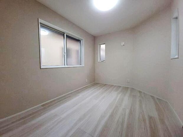 お部屋の各所に配置された窓から自然光が広がり、明るく爽やかな雰囲気を演出します。淡い色合いの木目調フローリングとシンプルな内装が調和し、心安らぐリラックスした時間を過ごせる洋室です。