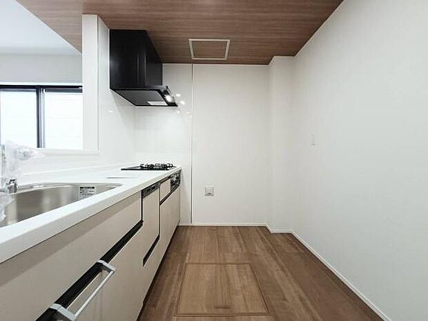 木目調の折り下げ天井がアクセントとなるキッチン空間。作業効率を考えたI型レイアウトを採用しており、調理から配膳までの一連の動線がスムーズに行える機能的な設計です。