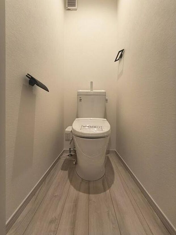白を基調とした明るく清潔感あふれるトイレ空間です。お手入れがしやすいシンプルなデザインの便器を採用し、日々の掃除の手間を軽減。温水洗浄便座を完備しています。