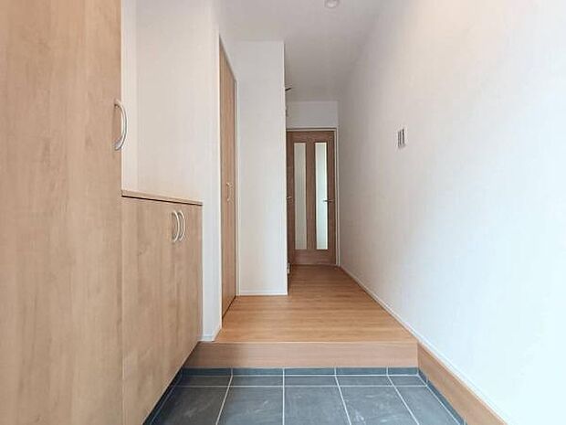 温かみのある木目調の建具と白を基調とした内装が調和した、明るく清潔感のある玄関スペース。たっぷりと靴を収納できるシューズボックスを完備しています。