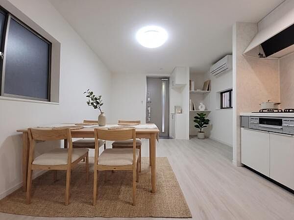 フルリノベーションで美しく生まれ変わった室内。元店舗を活かした広々とした開放感が魅力の空間です。エアコンも完備され、快適な毎日をサポートします。（家具・調度品はAI生成となります。）