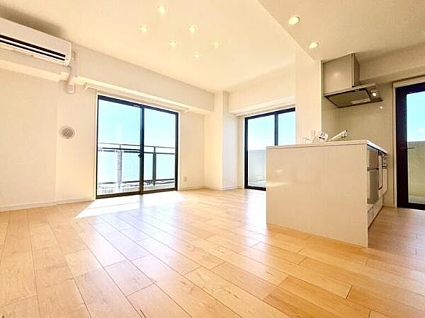 複数の窓から心地よい光と風が差し込む、開放感あふれるLDK。明るい木目のフローリングと白を基調としたクロスが美しく調和し、家具のレイアウトもしやすいすっきりとした空間に仕上がっています。