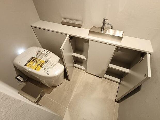 トイレ空間をスマートに彩る、収納一体型の手洗いカウンターを採用しました。散らかりがちな掃除用具やトイレットペーパーなどの備品も、たっぷりのキャビネット内にすっきりと収納可能です。