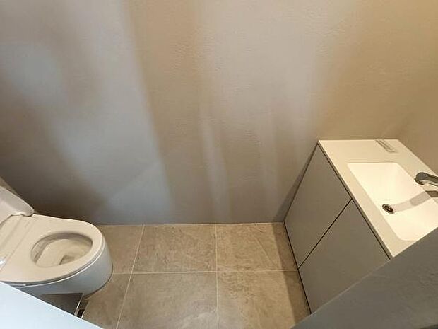 トイレ空間をスマートに彩る、収納一体型の手洗いカウンターを採用しました。散らかりがちな掃除用具やトイレットペーパーなどの備品も、たっぷりのキャビネット内にすっきりと収納可能です。