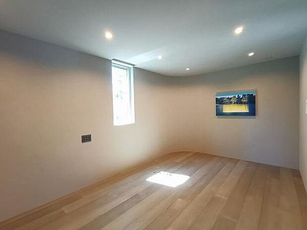 美しいアールを描く壁面が、空間に柔らかな広がりと独特の陰影を生み出している洋室。ミニマルなデザインの中に、計算された美意識が光ります。